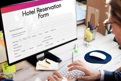Person completing hotel reservation form on computer screen.