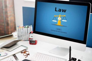 Computer screen shows 'Law' with justice scales on desk.